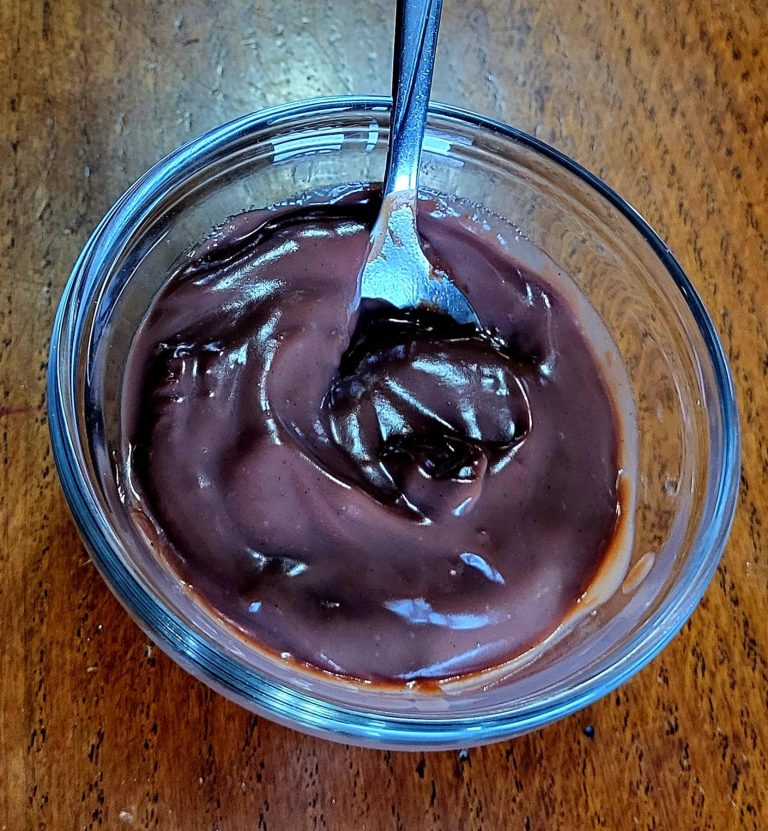 Homemade Chocolate pudding in a clear dish with a spoon